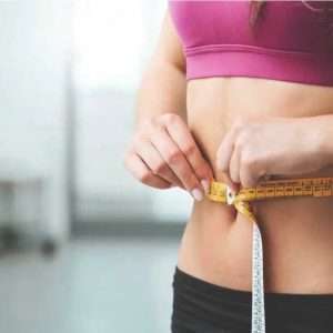 Woman measuring waist line for the Weight Loss program