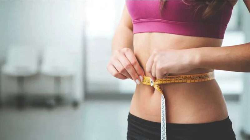 Woman measuring waist line for the Weight Loss program